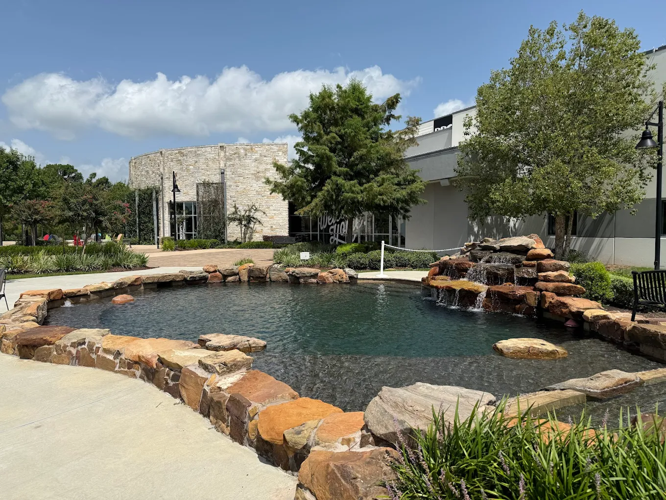 Commercial community pool with a rock waterfall feature