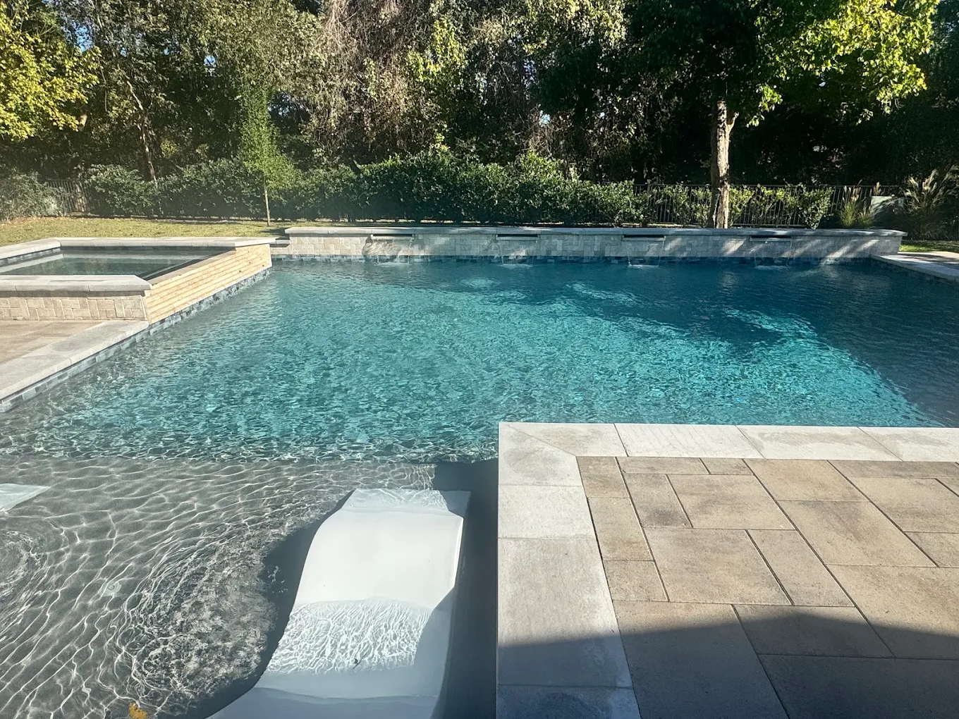 Modern pool with a tanning ledge and crystal-clear water